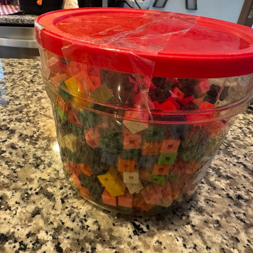 Clear Plastic Container with Red Lid Filled with Multicolor small blocks